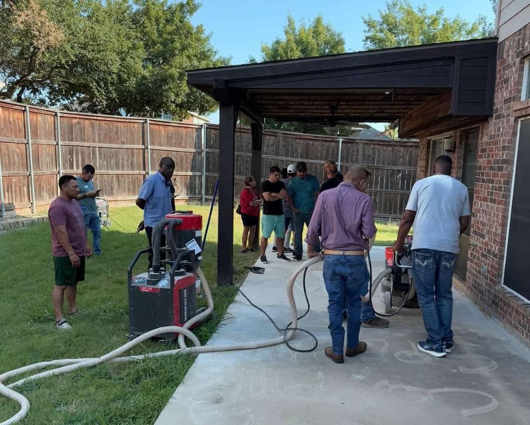 Contractors learning concrete grinding techniques as part of epoxy and polyaspartic coatings training