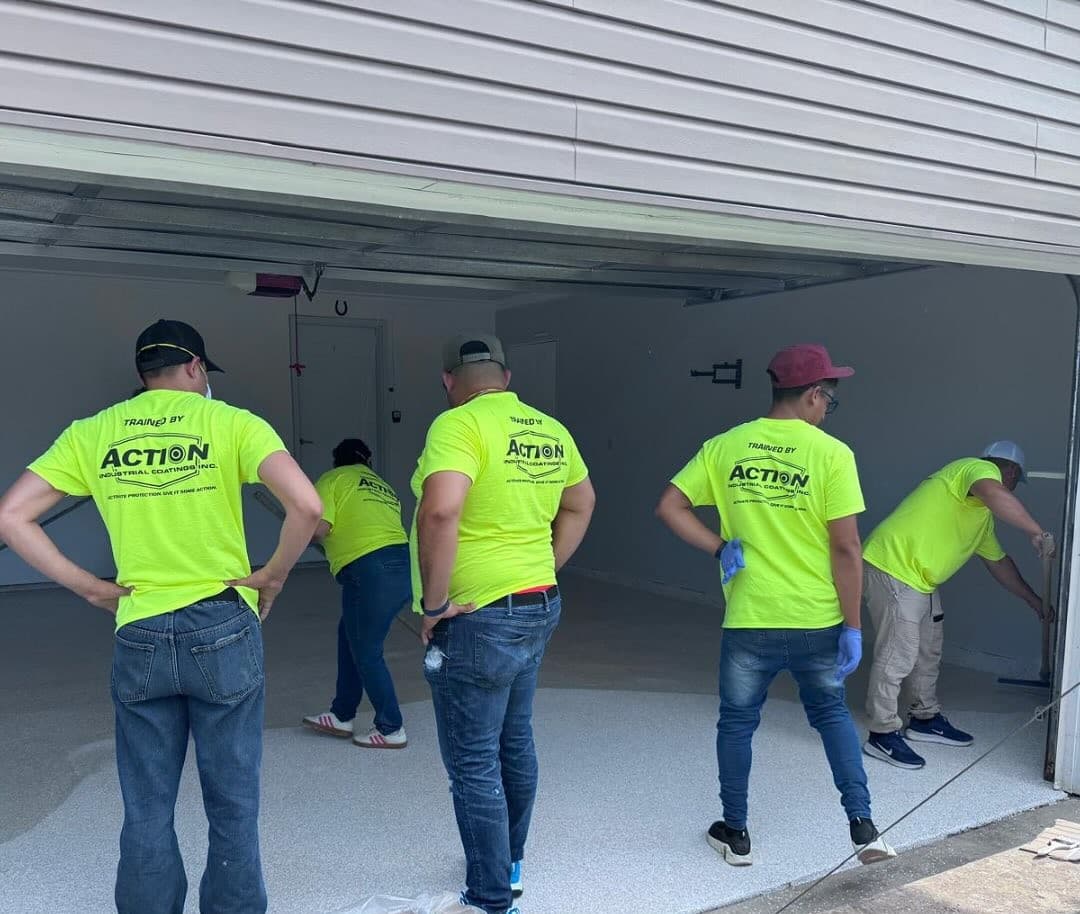 Installers applying epoxy floor coatings during hands-on training with Action Industrial Coatings