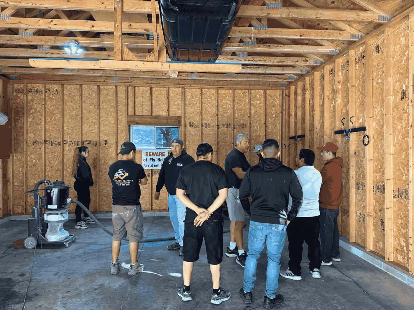 Students participating in hands-on epoxy coatings training inside a garage jobsite environment