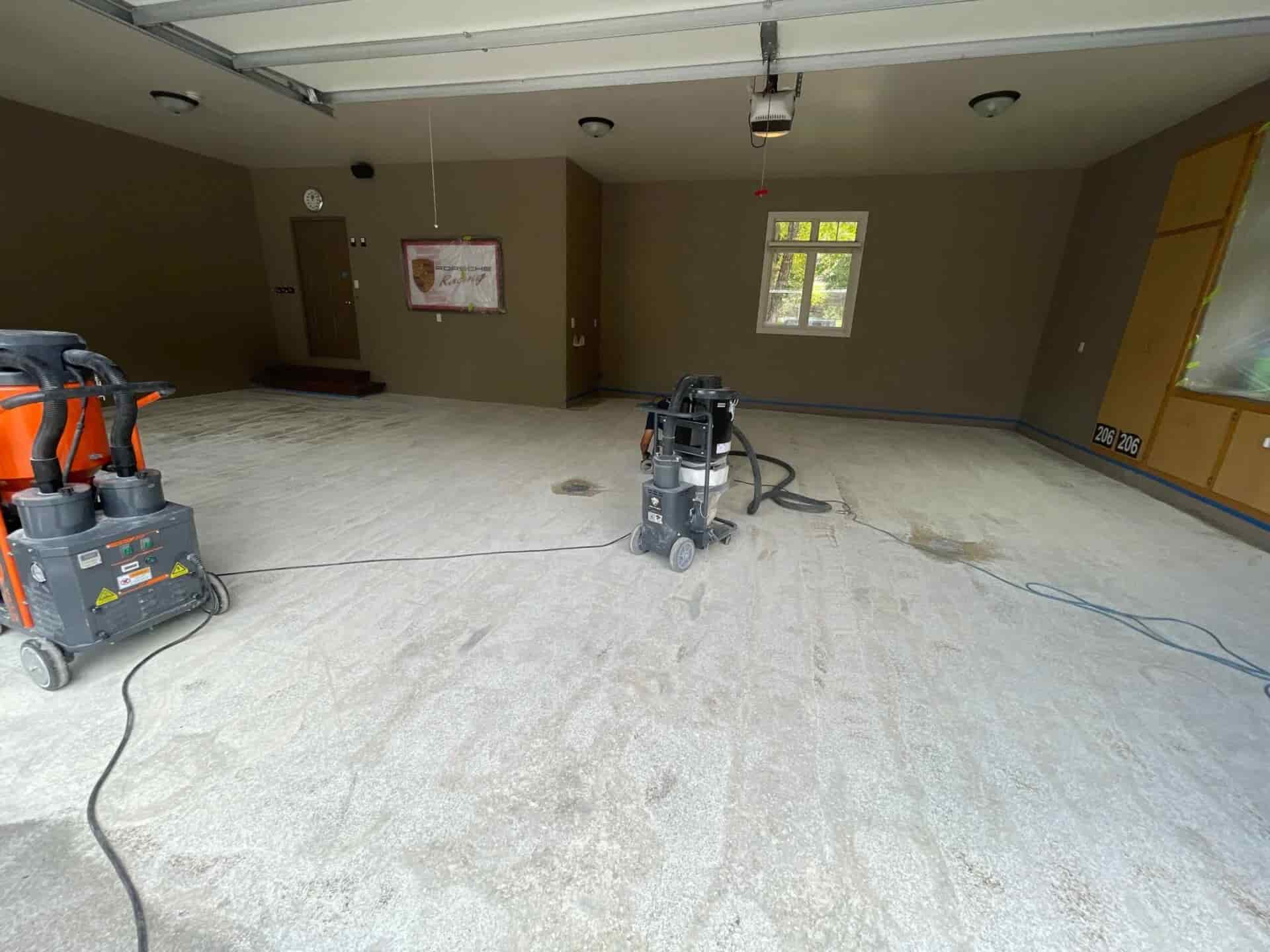 Concrete garage floor prepared using floor grinding equipment and industrial vacuum for dust control prior to coating installation.