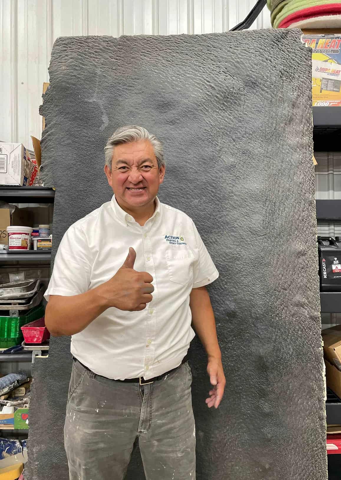 Ruben Contreras standing in workshop with polyurea coating sample used for contractor training and testing